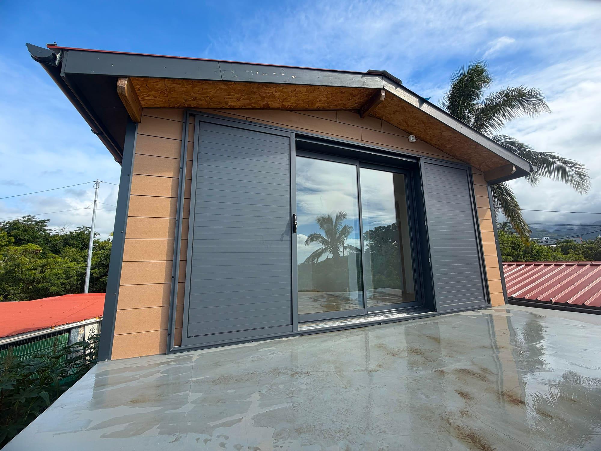 Baie vitrée aluminium ouverte donnant sur un palmier, La Réunion