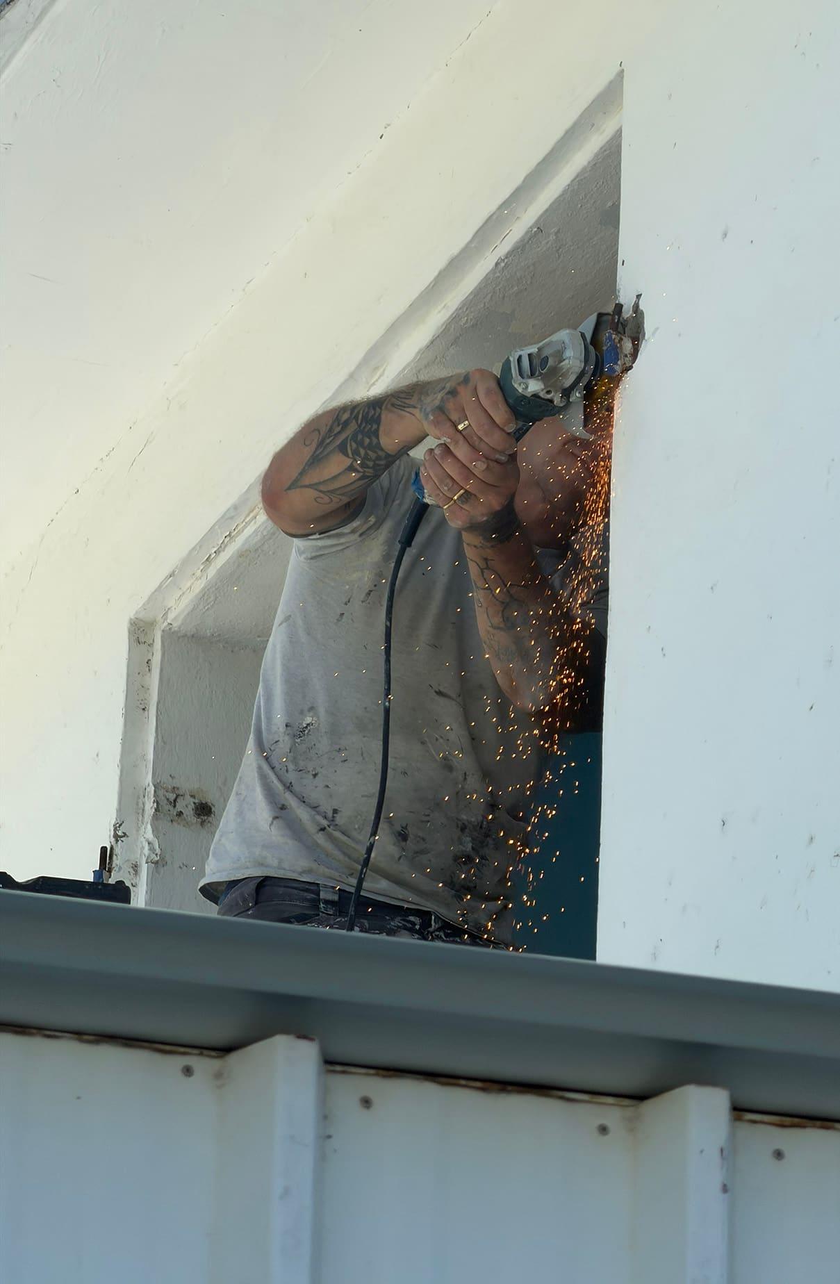 Installateur ajustant une fenêtre à la meuleuse